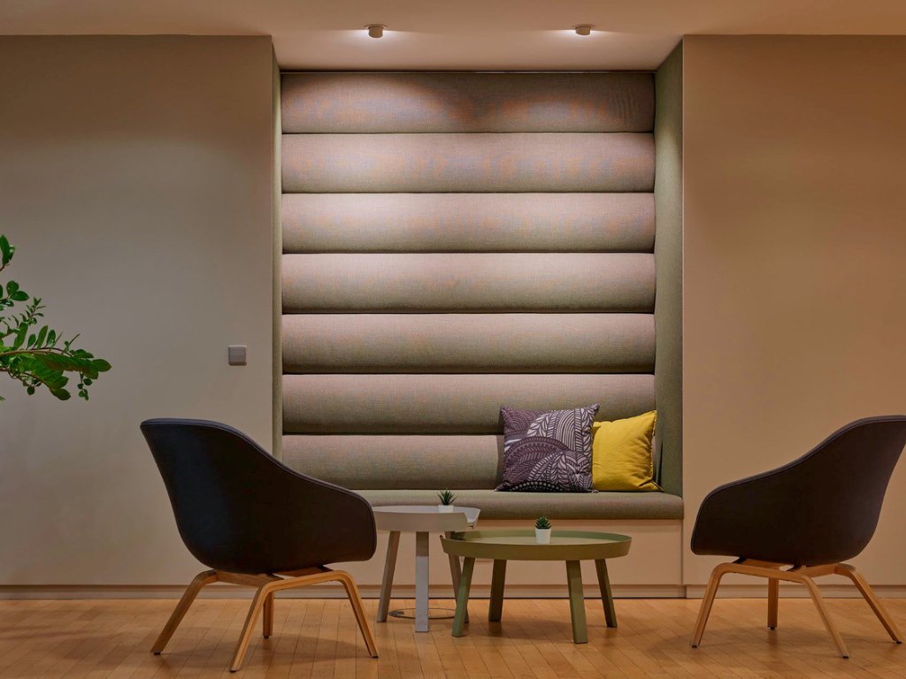 graue-sessel-vor-einer-beleuchteten-wand