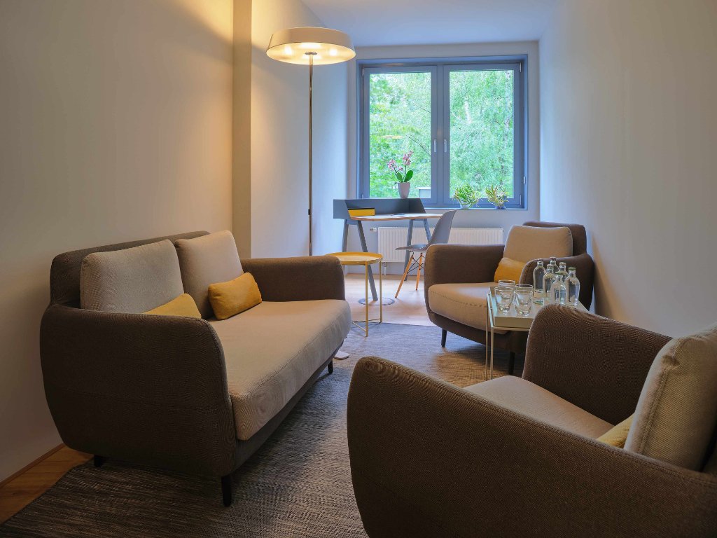 kleiner bueroraum mit fenster, couch und zwei sessel