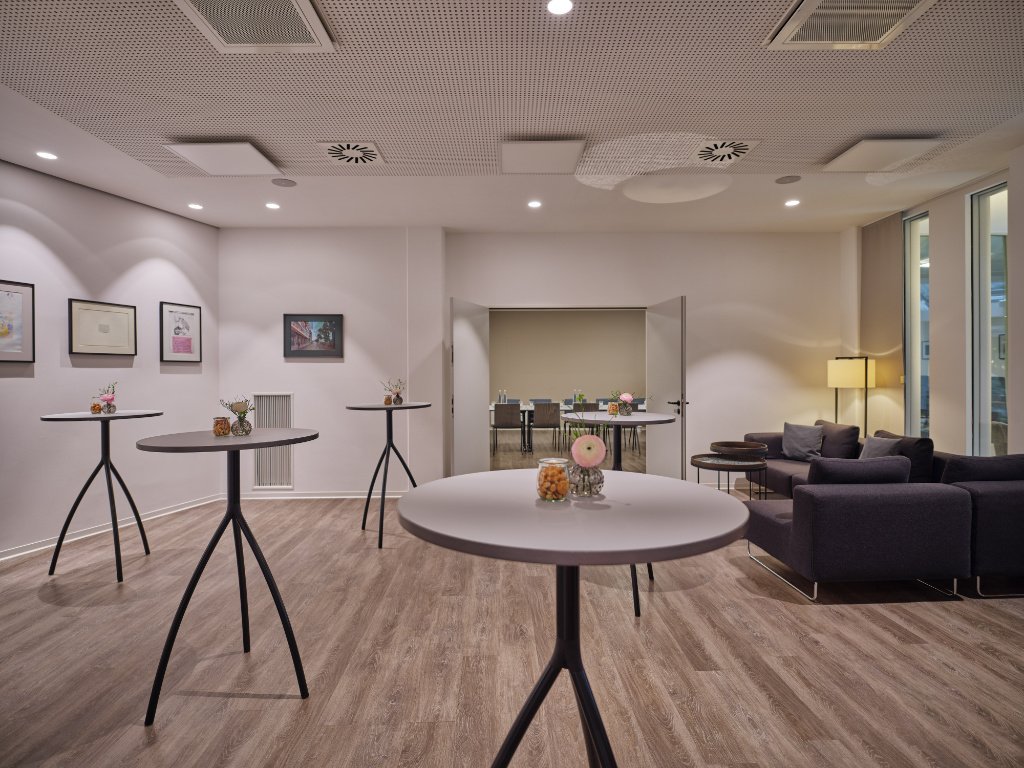 raum-graue-couch-stehtische