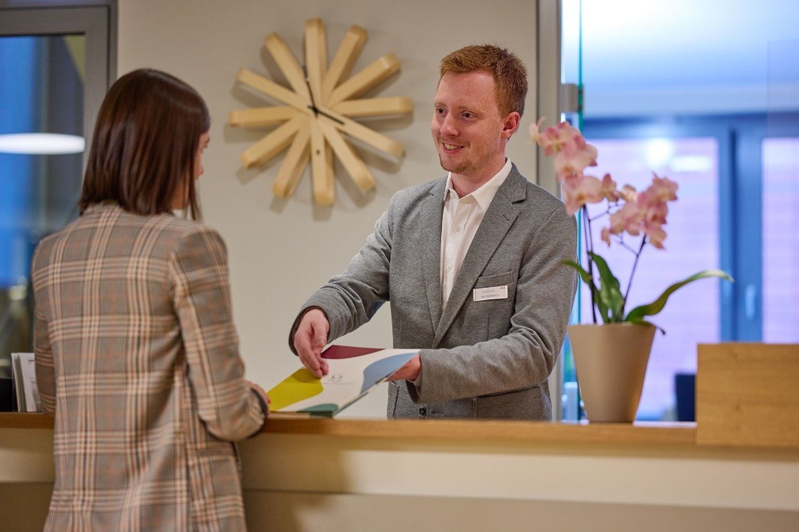 mitarbeiter-uebergibt-kunde-unterlagen