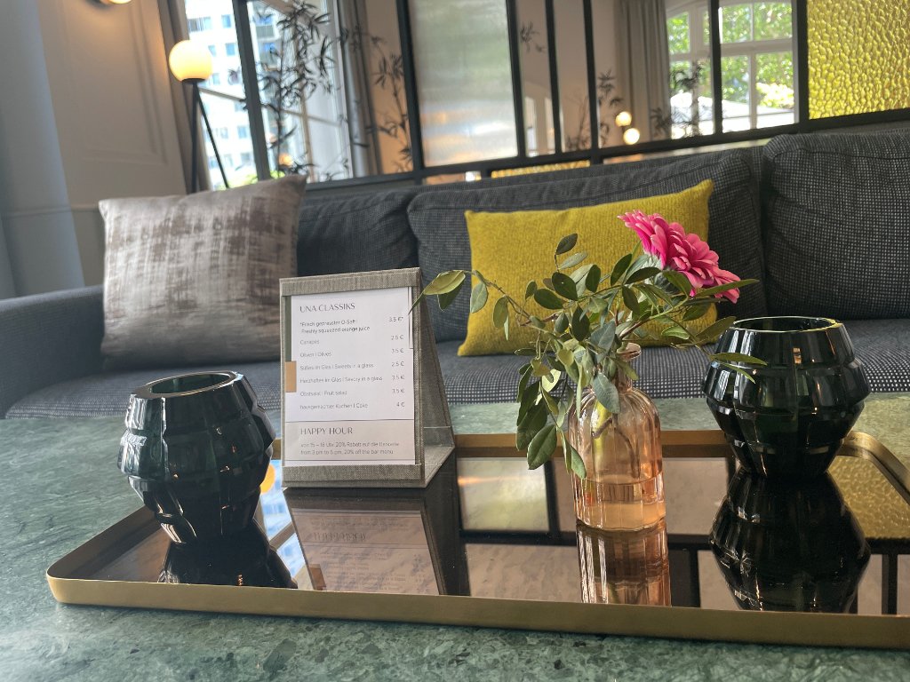 goldenes Tablet mit kleiner Vase und Blume und einem Aufsteller mit Snackangebot
